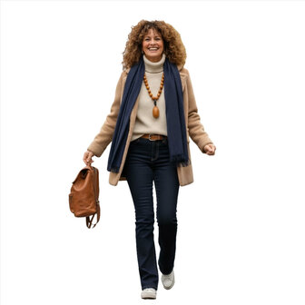 Een dame in Anna Montana Finja flared jeans in blueblack, gecombineerd met een klassieke camel jas.